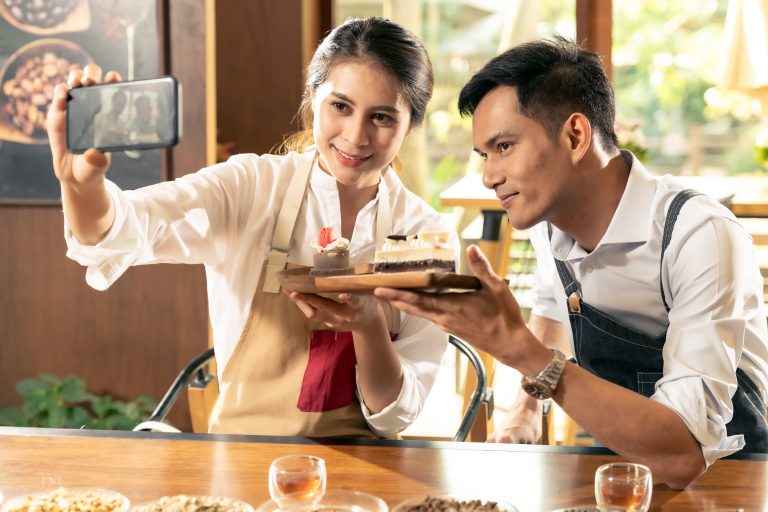 two people taking a picture of their cakes